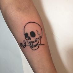 a black and white skull with a rose tattoo on the arm