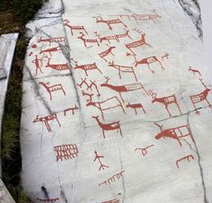 an artistic rock painting with animals and people on it