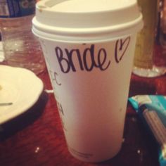 a coffee cup with the word bride on it sitting on a table next to a napkin