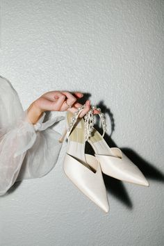 a woman holding two pairs of white shoes