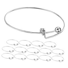 a bunch of silver metal bracelets with balls on each end and one ball in the middle