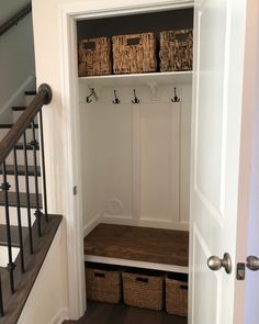 an entryway with storage baskets and stairs