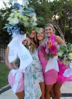 three beautiful young women standing next to each other holding bouquets and posing for the camera