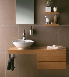 a bathroom with a sink, mirror and shelves on the wall next to each other