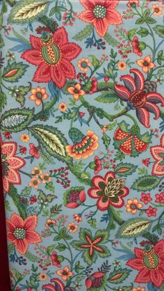 a blue and red flowered fabric with green leaves