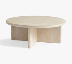 a round wooden table sitting on top of a white floor