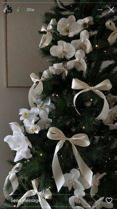 a christmas tree decorated with white flowers and lights