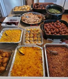 a table filled with lots of different types of food on pans and trays