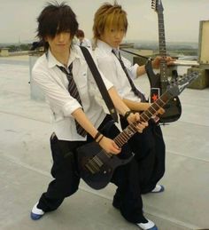 two young men are holding guitars and posing for the camera