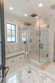 a bathroom with marble flooring and white walls, along with a walk in shower