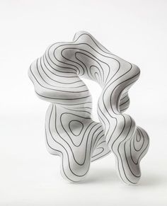 an abstract white sculpture with wavy lines on it's sides, against a white background