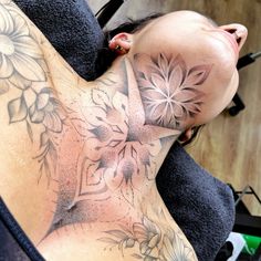 a woman with a tattoo on her back is laying down and looking at the camera