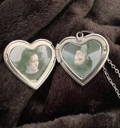 two heart shaped lockes with a photo inside them on a chain attached to a blanket