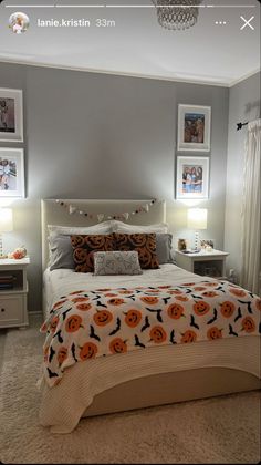 a bedroom decorated for halloween with pumpkins on the bed and pictures hanging above it