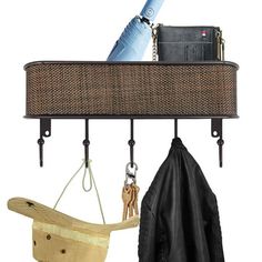 an umbrella, hat and purse hanging from hooks on a wall with other items attached to it