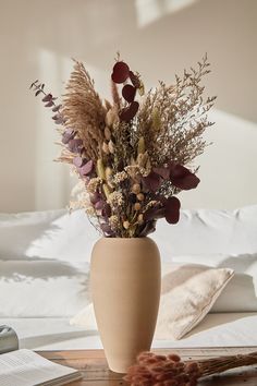 a vase filled with flowers sitting on top of a table next to an open book