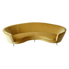 a curved couch with metal legs and a yellow velvet upholstered back, viewed from the front