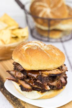 a pulled pork sandwich sitting on top of a white plate