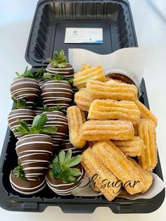 chocolate covered strawberries and dipped strawberries in a black container with white writing on it