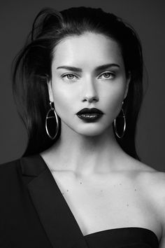 a woman with black lipstick and large hoop earrings