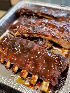 two ribs covered in bbq sauce and banana slices on top of tin foil lined baking pan