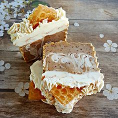 three pieces of cake sitting on top of a wooden table covered in frosting and flowers