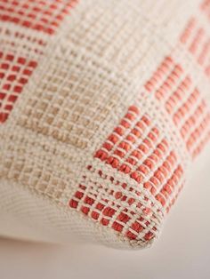 a close up view of a red and white pillow