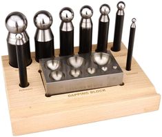 an assortment of metal tools on a wooden stand