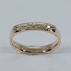 a gold wedding ring with three diamonds on it