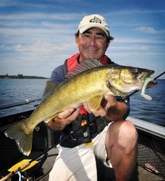 a man on a boat holding a large fish