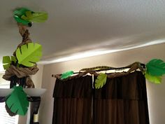 some paper leaves hanging from the ceiling in front of curtains and window sills