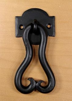 a black metal hook on a wooden surface