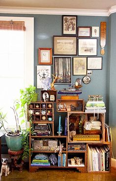 a living room filled with lots of furniture and pictures on the wall next to a window