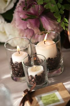 three candles with coffee beans in them on a table