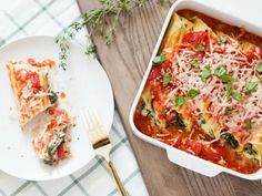 a white plate topped with lasagna next to a casserole dish