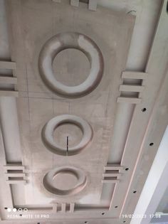 the ceiling is covered in white plaster and has three circles on each side, as well as four smaller circular objects