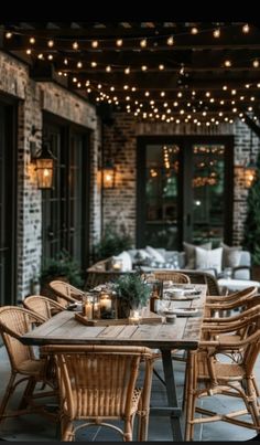 an outdoor dining area with wicker furniture and string lights