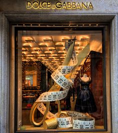 a store window with tape wrapped around it's mannequins and dresses