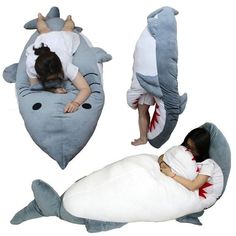 two children sleeping on shark shaped pillows with one child laying on the pillow while another sleeps