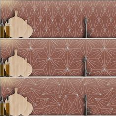 three wooden cutting boards sitting next to each other in front of a wall with geometric designs