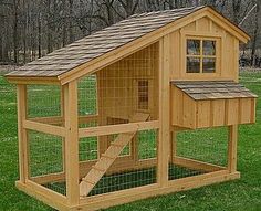 a wooden chicken coop in the grass