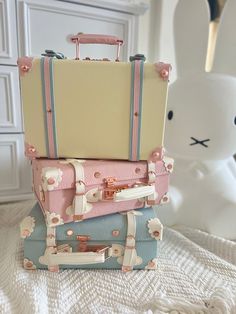 three suitcases stacked on top of each other in front of a white bunny statue