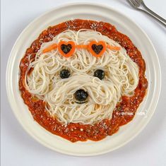 a white plate topped with spaghetti and a dog face