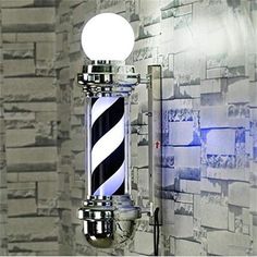 a barber pole with a light on it in front of a wallpapered background