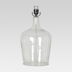 a clear glass bottle with a silver stopper on the top is shown in front of a white background