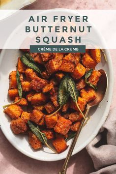 a white bowl filled with butternut squash and sage on top of a pink table