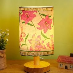 a lamp that is sitting on top of a wooden table next to a potted plant