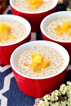 three red bowls filled with oatmeal and fruit on top of a table