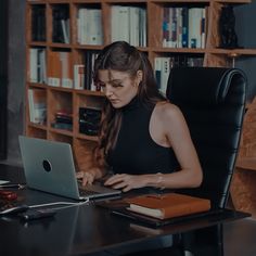 a woman sitting at a desk using a laptop computer