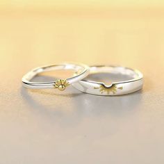 two gold wedding rings sitting on top of a table